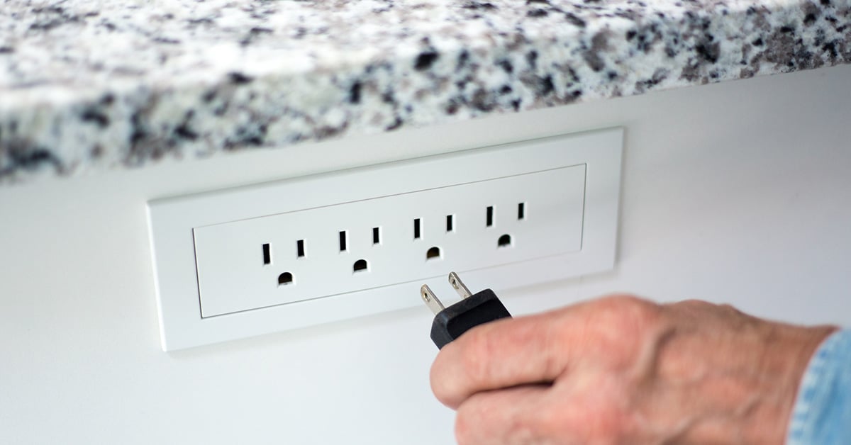 Mans hand putting plug into socket