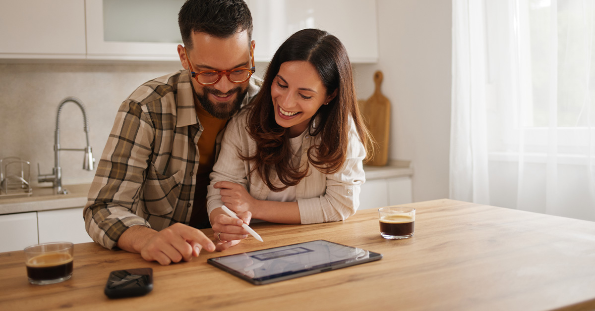 Young couple enjoying coffee and digital tablet at home