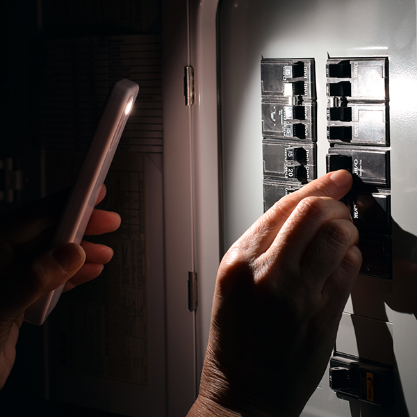 A homeowner resets the breaker panel after an electrical malfunction. A homeowner resets the breaker panel after an electrical malfunction.