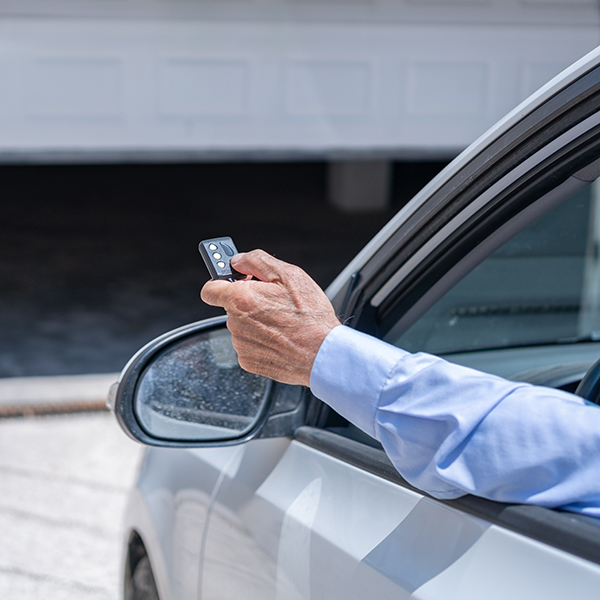 A man using his remote control to open his garage door. A man using his remote control to open his garage door.