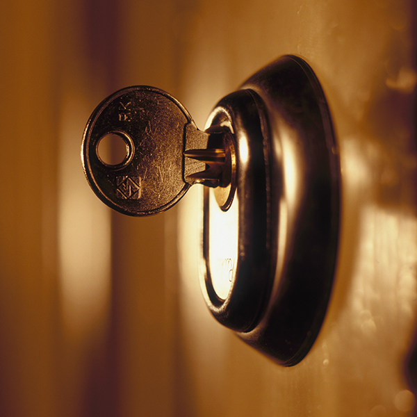 A front door lock with the key hanging out. A front door lock with the key hanging out.