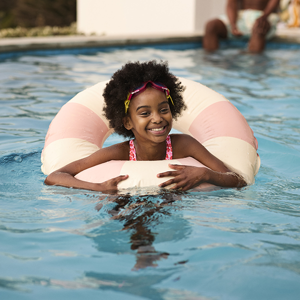 A young girl floating in the family pool A young girl floating in the family pool